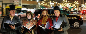 Strolling carolers sing in beautifully lit Downtown street during holidays